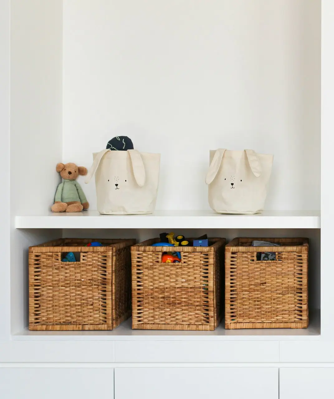 a shelf with baskets and a teddy bear on it